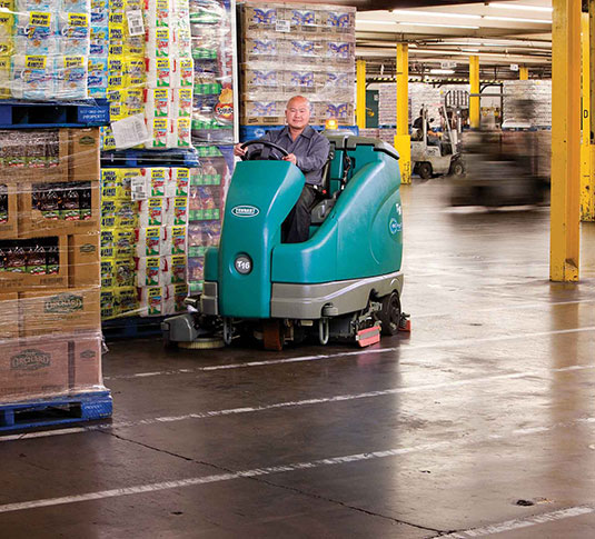 Une récureuse autoportée T16 Tennant dans un entrepôt Une récureuse autoportée T16 Tennant dans un entrepôt